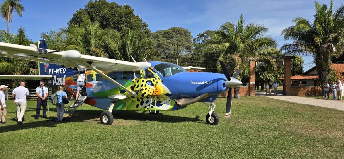 Passageiros embarcando em Grand Caravan na pista de grama ao lado da pousada, Porto Jofre, Pantanal
