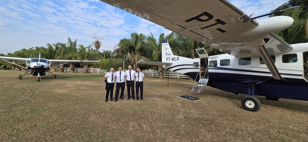 Tripulação de voo ao lado de dois Cessna Grand Caravan em pista de grama no Pantanal Norte