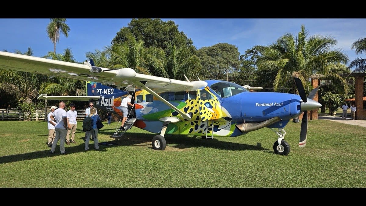 Cessna Grand Caravan C208B com pintura de onca-pintada estacionado na pista de grama de uma pousada em Porto Jofre, Pantanal Norte